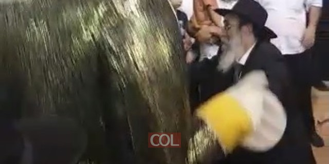 הרב מנחם מנדל גלוכובסקי רוקד עם בובת-ענק בשמחת בית השואבה של קהילת חב