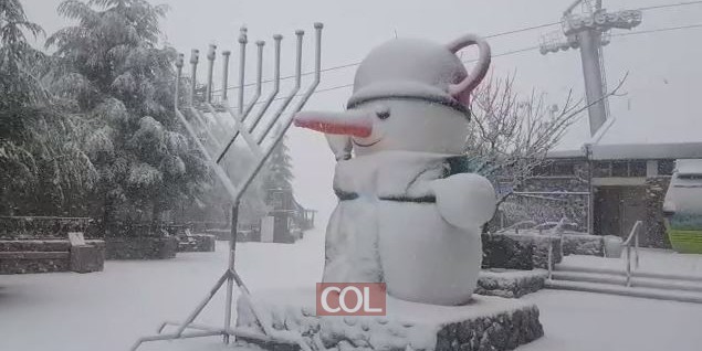 השלג מתחזק באתר החרמון. בחזית הכניסה לאתר: חנוכייה של חב