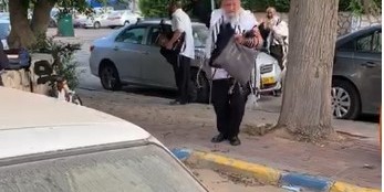 טייערע ברידער: הרב אליהו ניימרק מלוד שממריא הלילה לשליחות עם רעייתו לעיר הנובר בגרמניה, בריקוד חסידי לאחר תפילת שחרית ליד ביתו בשכונת חב