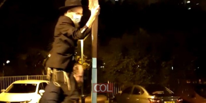 כשאין סולם בנמצא: שליח הרבי ביהוד הרב שמואל וולף מרים על כתפיו את ידידו השליח הרב שמעון ויינר בכדי שידליק את החנוכייה 