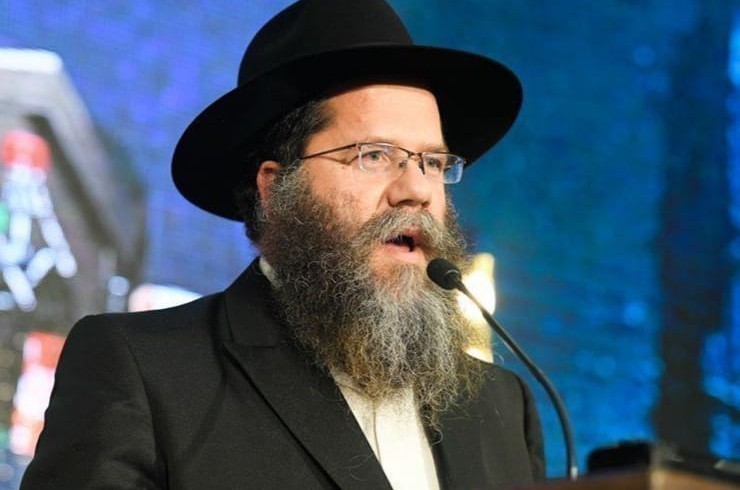 האם צריך לאחוז את הלחם משנה בידיים, ומנהג הרבי בזה