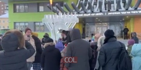 במינוס 30 על מנורה מקרח: הרב הראשי לרוסיה השליח הרב בערל לאזאר בהדלקת נר חמישי, בחזית בית הספר היהודי הגדול 