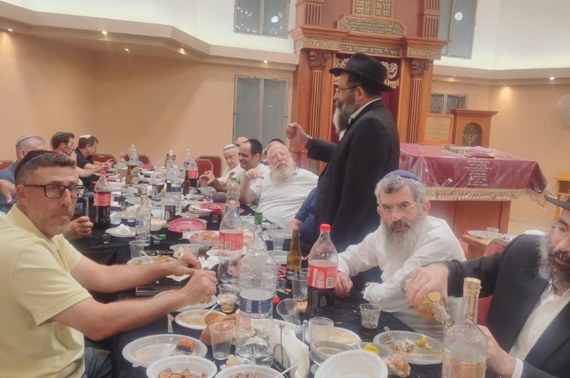 סביב שולחנות ערוכים: מתפללי בית הכנסת וחברי הקהילה בהתוועדות חג הגאולה י