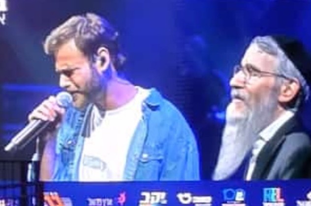 הבעל מנגן החסידי ר' אברהם פריד בשירה משותפת עם שורד השבי אלון אהל, במופע השנתי בבריכת הסולטן